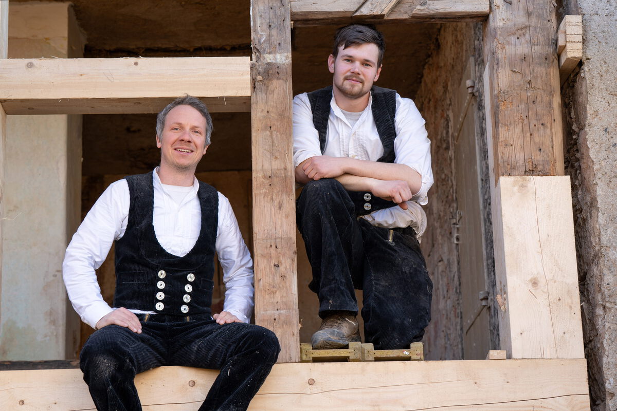 Steffen und Jost inmitten ihrer Arbeit – sie sitzen im Holzfachwerk