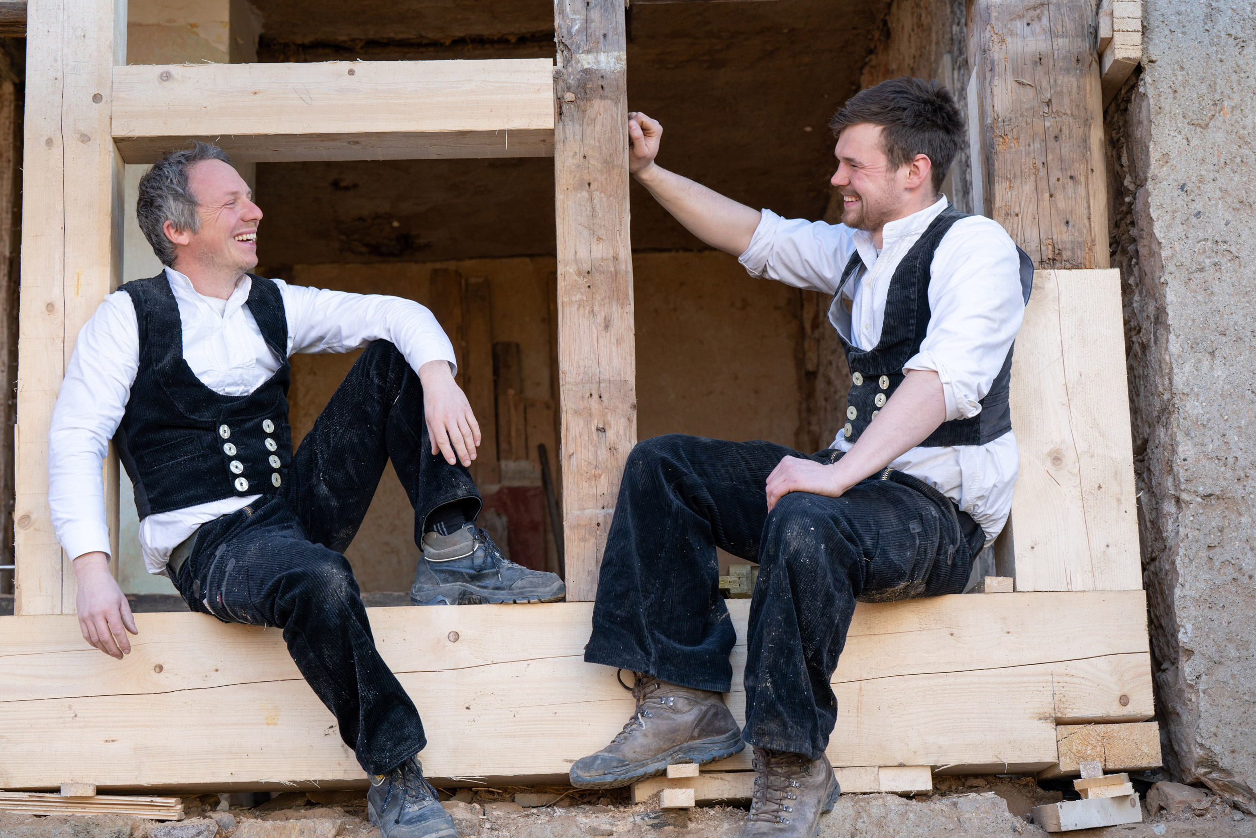 Steffen und Jost inmitten ihrer Arbeit – sie sitzen im Holzfachwerk